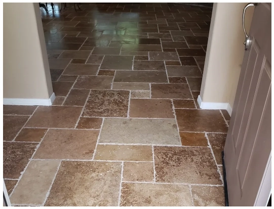 A tile floor with some brown and beige tiles