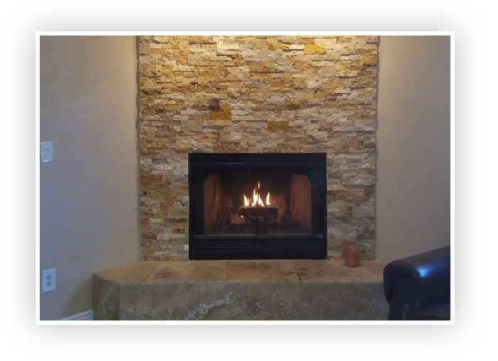 A fireplace with stone surround and hearth in living room.