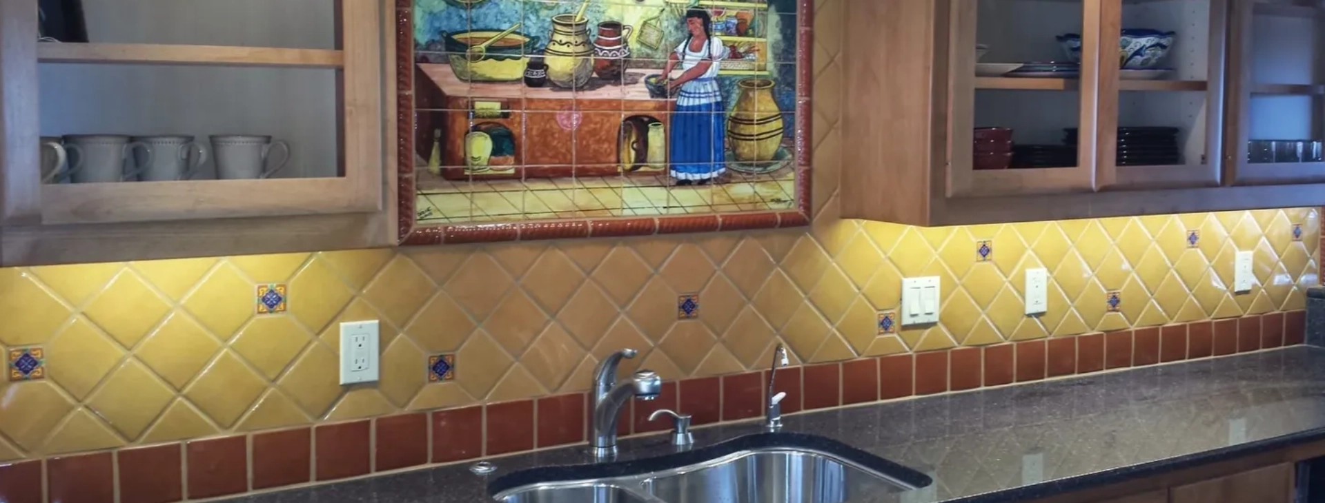 A kitchen with a sink and a mural on the wall